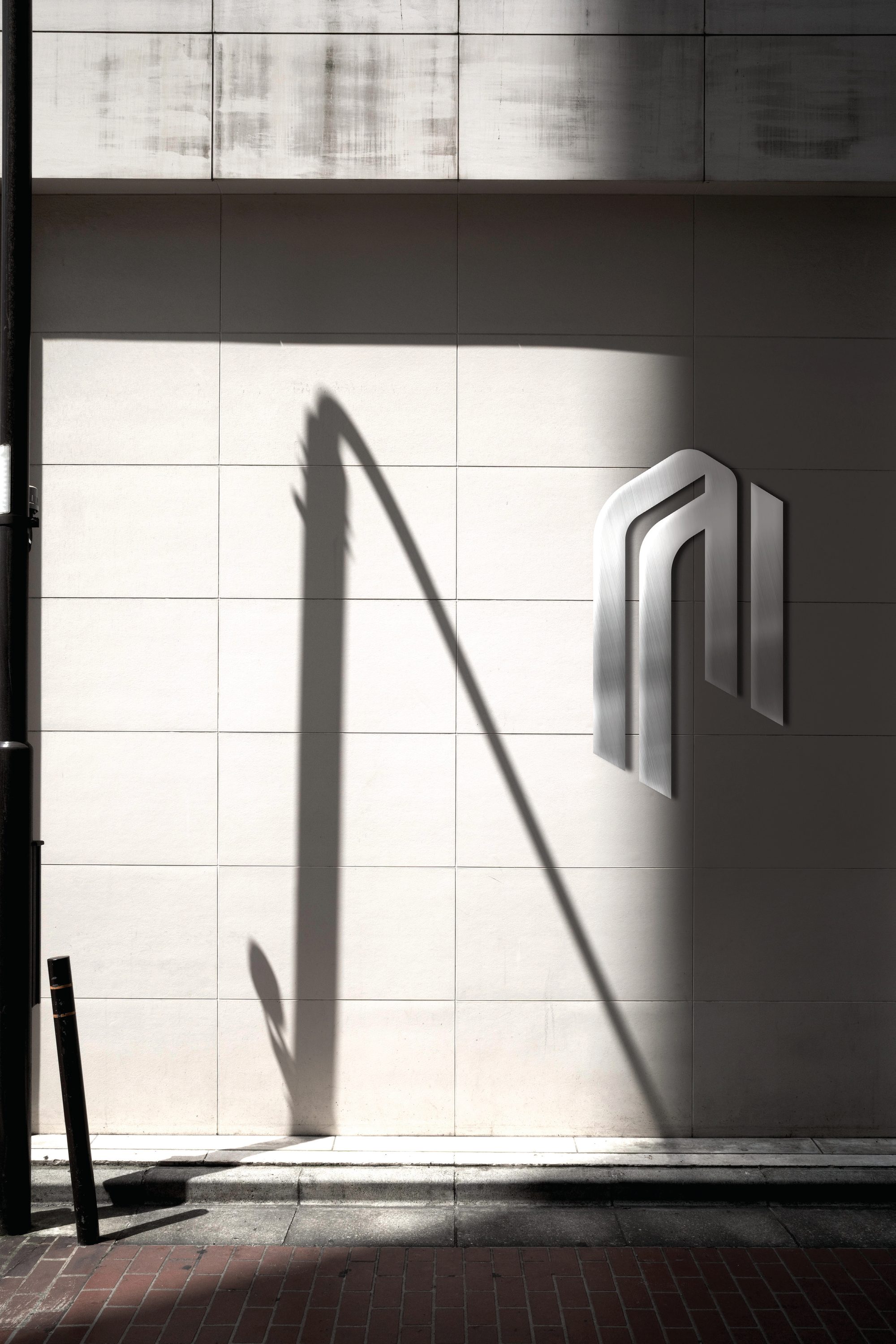 The PONTIKIS emblem on a metal sign, on a wall with strong shadows